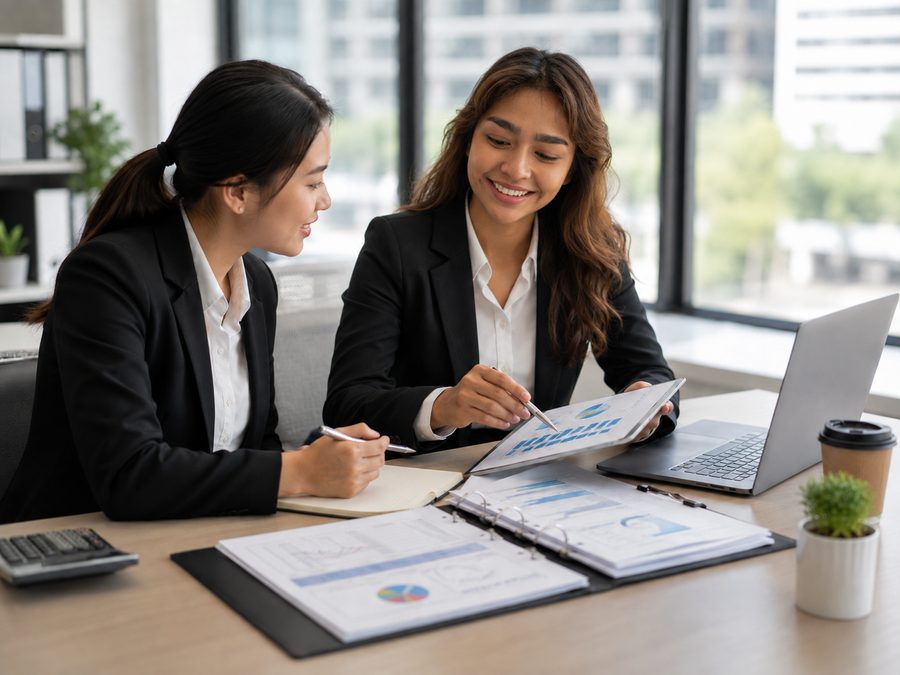 Two colleagues reviewing business financial charts together